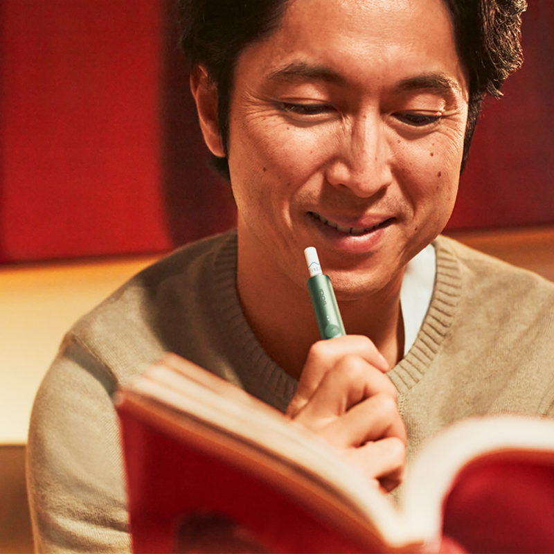 IQOSとマンガを読む男性